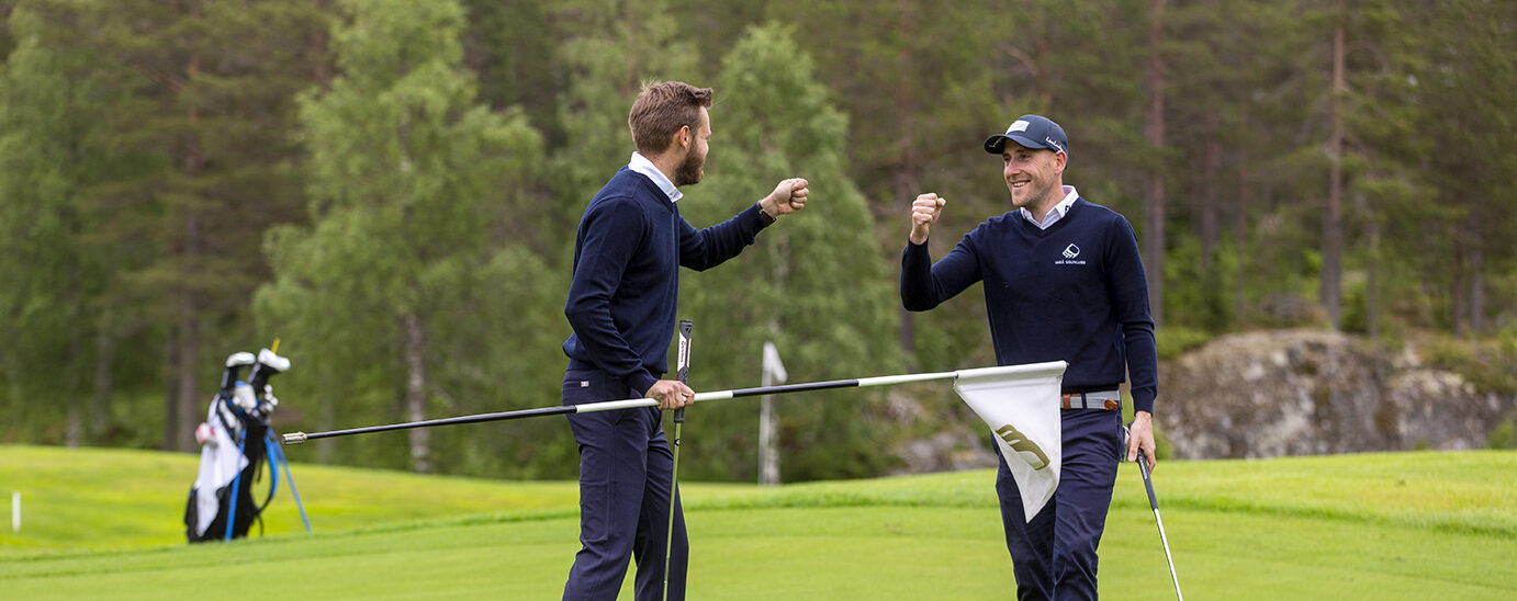Två glada golfare som gör segergest genom att slå knytnävar mot varandra.
